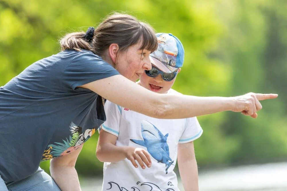 Eine Betreuerin spielt mit einem Jungen mit Beeinträchtigung